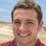 Smiling man by beach with waves — Aipick Zone